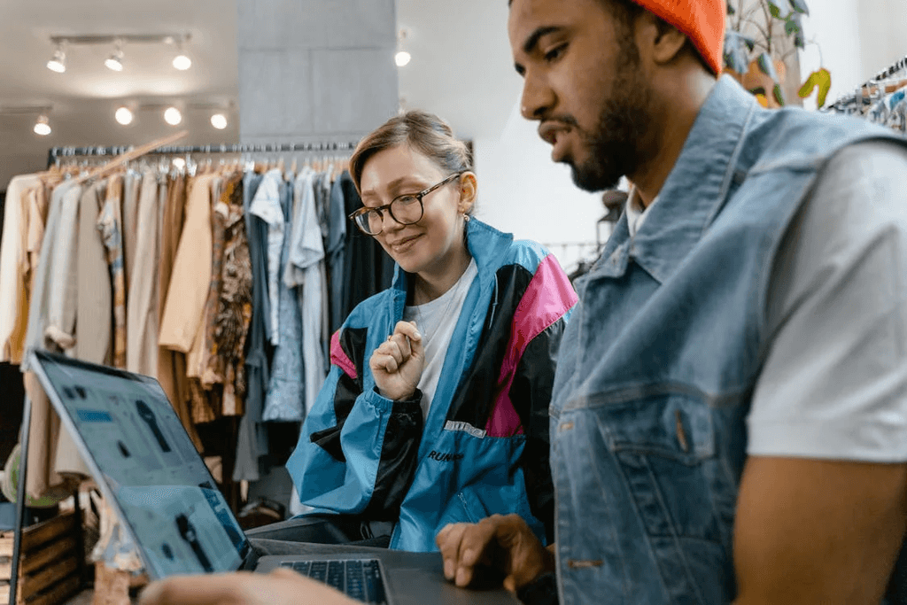 A Man and a Woman Looking at A Laptop Screen Wondering if Does Changing Shopify Theme Affect SEO